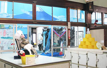 梅乃湯の脱衣場と奥の富士山のタイル絵が見える浴室の写真